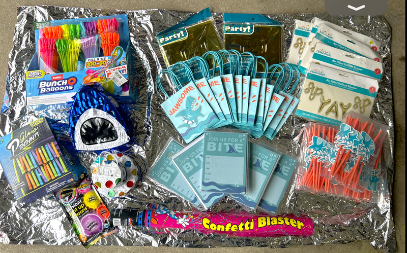 Prize #2 - Shark party basket: Shark party invitations, shark goodie bags, shark straws, table cloths, two mini piñatas, confetti blaster, easy to fill water balloons, regular balloons, large box of glow sticks